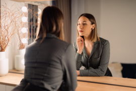 Девушка смотрится в зеркало