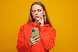 Девушка задумалась с телефоном